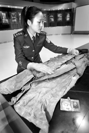 民警对芦振龙牺牲时所穿的长裤进行整理本报记者 李文彬 摄